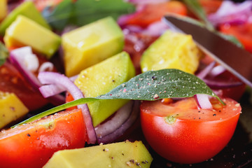 Colorful and tasty salad with avocado, cherry tomatoes and mozzarella, details, macro