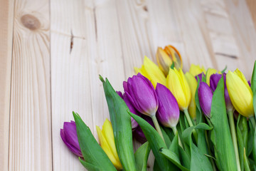 Bouquet of colorful tulips on a light wooden background gift for March 8 top view