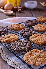 Thin, tasty, crunchy chocolate and caramel cookies on a black metal grid, vertical