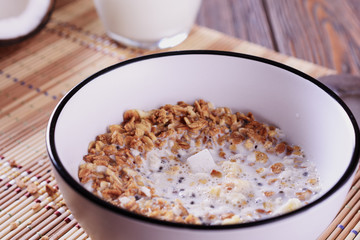 Healthy and tasty granola breakfast with coconut pieces and milk, macro