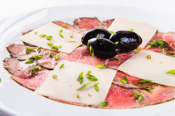 Veal carpaccio on white background close up. A traditional Italian dish.