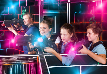 Fototapeta na wymiar Kids and adults playing lasertag