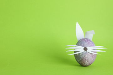 Decorated Easter egg and cute bunny's ears on color background. Space for text