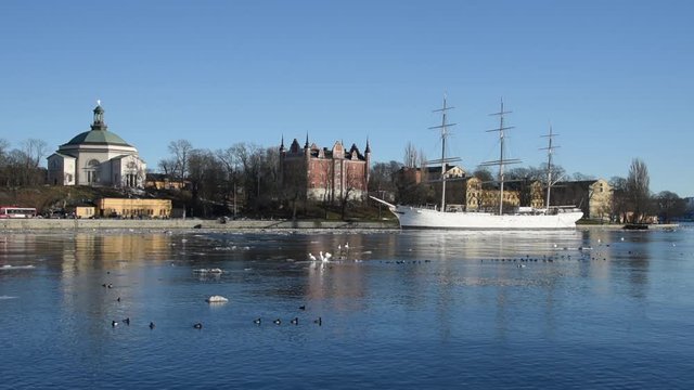 An early sunny spring day in Stockholm, birds and ice drifting on flow of meltwater