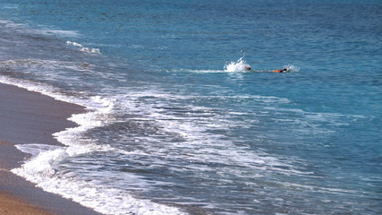 swimming in the sea. man swims from the coast into the sea.
