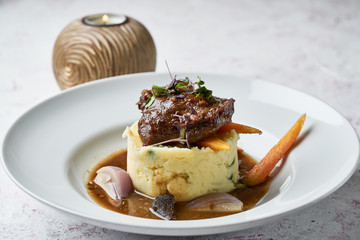 Delicious beef tenderloin with herbs and potato mash on a white plate