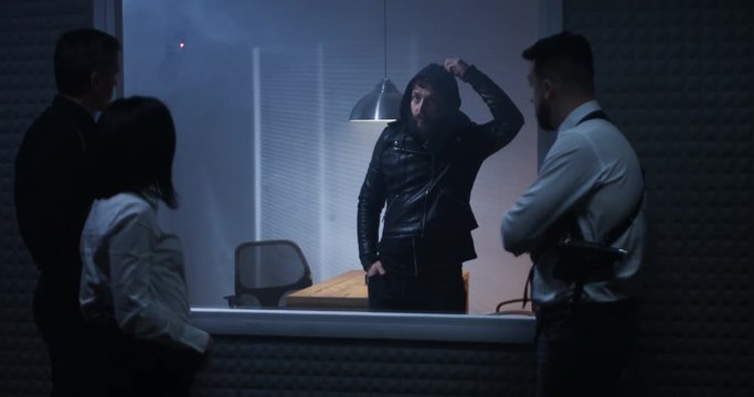 Policemen having fun with criminal behind glass