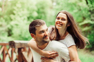 Young happy couple in summer park. Man and woman happy relathionships, young family concept. Love, youth, togetherness concept