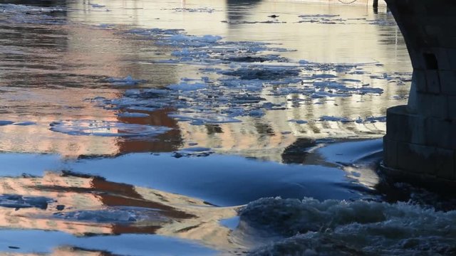 Melt water and ice flakes under a bridge in Stockholm an early sunny spring day