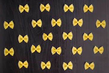 Pattern of A pile of farfalle pasta on black background
