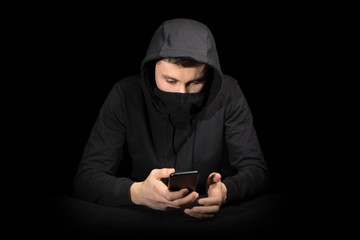 Hacker with mobile phone initiating cyber attack, isolated on black