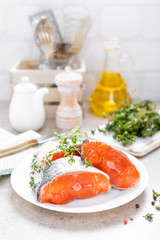 Fresh raw salmon fish steaks on white kitchen background