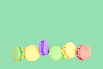 Delicious macarons on green background