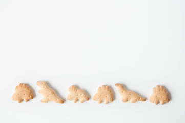 Crackers, baby cookies, dinosaurs on a white background. Baby food. Food snack for school children...