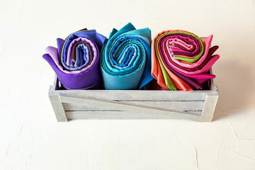 Rolled up colorful fabric swatches on white background