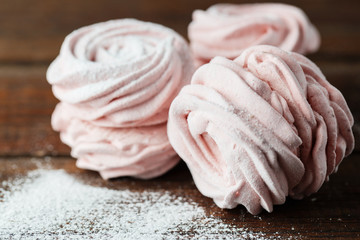 The process of making zephyr marshmallow at pastry shop kitchen. Fresh pink fruit marshmallow roses on wooden background.