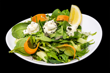 green spinach salad with philadelphia in white plate on a black background 
