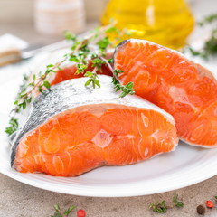 Fresh raw salmon fish steaks on white kitchen background