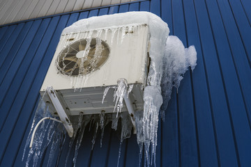 Air conditioning in ice, severe winter. White air conditioner