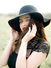 Young brunette woman wearing hat in nature