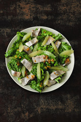 Salad with herring and lemon fillet. Paleo diet, keto diet, pegan diet. Healthy fitness salad with lemon and fish.