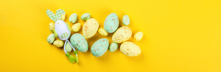 Easter background. Easter eggs  Colored, decorated with gold on yellow paper. Happy Festive concept.Top View. Flat Lay.Copy space for Text.Banner
