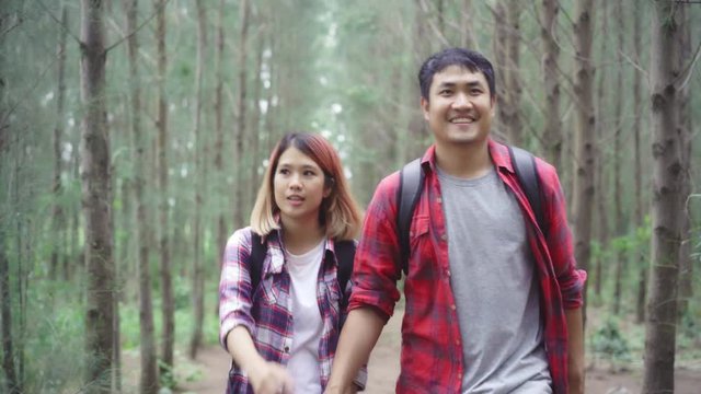 Hiker Asia backpacker couple on hiking adventure feeling freedom walking in forest, Sweet Asian couple enjoy their holidays near lots of tree. Lifestyle Couple travel and relax in freetime concept.