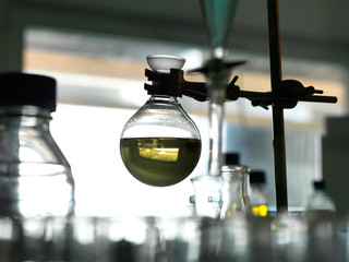 Flask containing a chemical formula being held by a retort stand in a laboratory