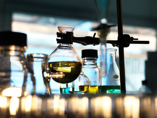Flask containing a chemical formula being held by a retort stand in a laboratory