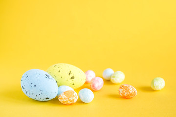Bright Easter decorative eggs on a yellow background, close up, soft focus. Easter background