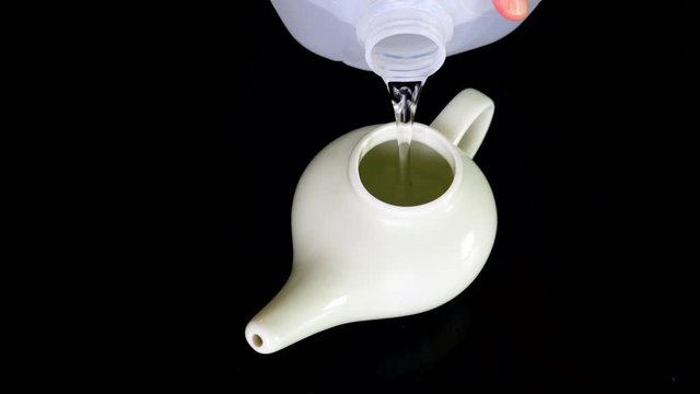 Neti pot being filled with distilled water