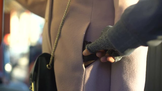 Thief stealing wallet from carefree ladies pocket in metro carriage, belongings