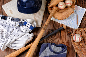 Overhead view of baseball gear on a rustic wood surface