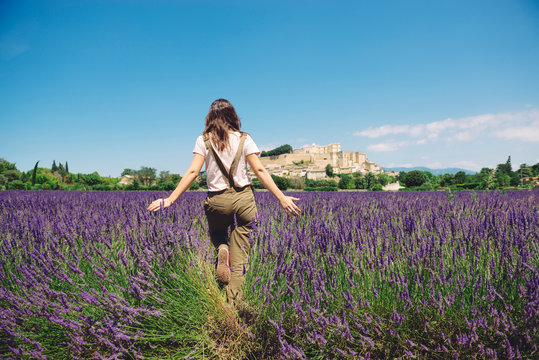 France, Grignan, back view of woman walking in lavender field