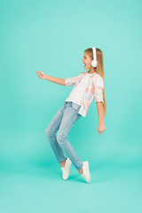 The tunes turning her mood around. Happy small girl dancing to music. Dancing girl. Small girl listening to music in headphones. Cute child enjoying happy dance music. Music is happiness for her