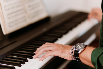Young man playing electric piano at home studio