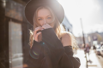 Portrait of woman with hat dressed in black at backlight