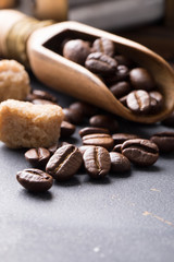 Black fried coffee beans on dark textured background