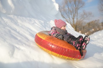 Child having fun on snow tube. 