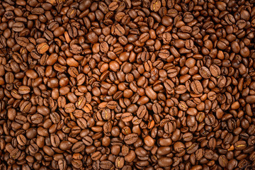 Coffee beans background. Roasted coffee beans with light vignetting.
