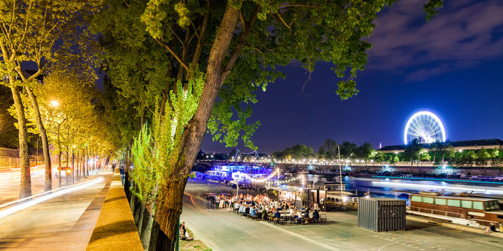 France, Paris, Champs-Elysees, Quai Anatole, people at River Seine bank at night