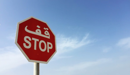 A road "Stop' sign in English and Arabic