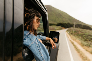 Woman looking through window while sitting in off-road vehicle