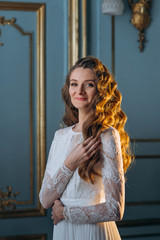 Obraz premium Portrait of young beautiful smiling gorgeous bride in her stylish wedding dress