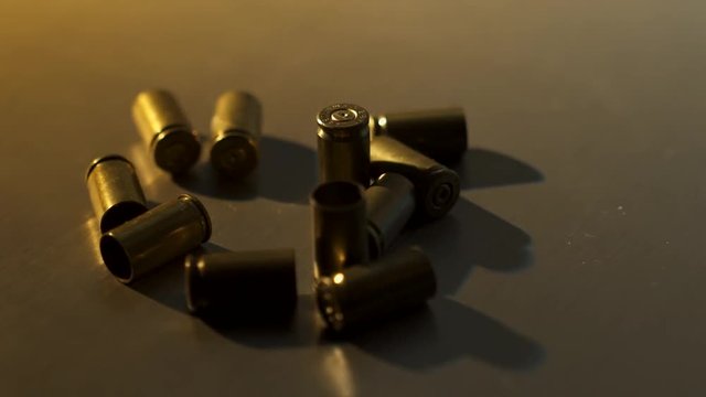 A collection of 9mm bullet shell casings on a dark background