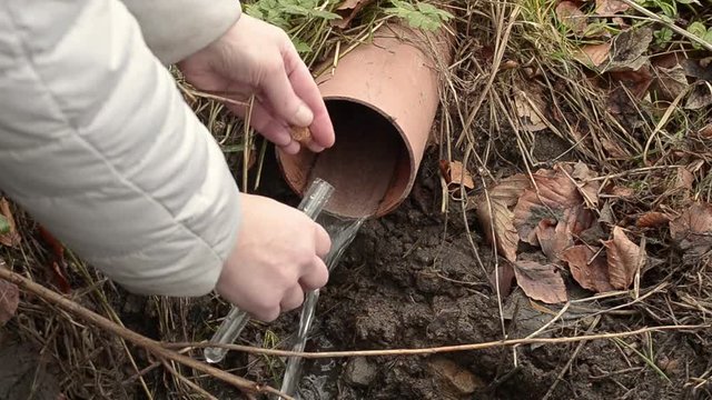 Collecting drain pipe water sample with test tube