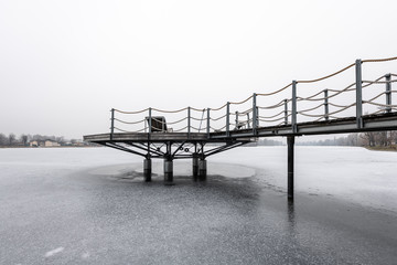 Public bathing place in winter, frozen water, lounger made of wood