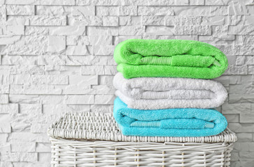 Obraz na płótnie Canvas Stack of clean towels on wicker basket