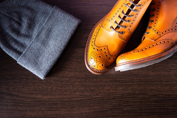 Fashion Ideas. Toes of Pair Male Tanned Leather Brogued Boots Along with Warm Hat on Wooden...