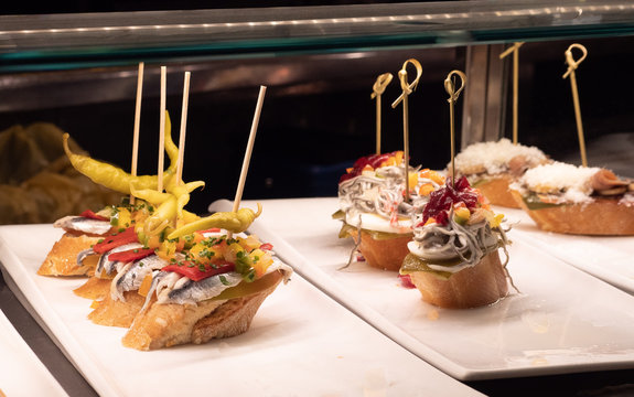 Showcase window display assortiment with tapas &ndash; traditional Spanish sandwiches in a cafe in Barcelona, Spain close up macro